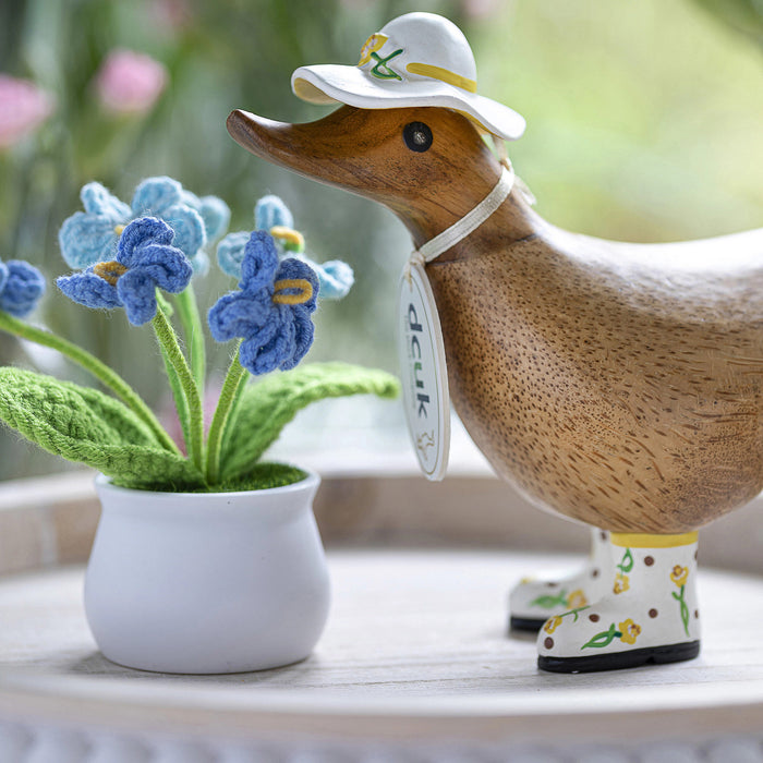 Handmade DCUK wood duckling with yellow daffodil flower hat and matching boots, showcasing intricate wooden craftsmanship.