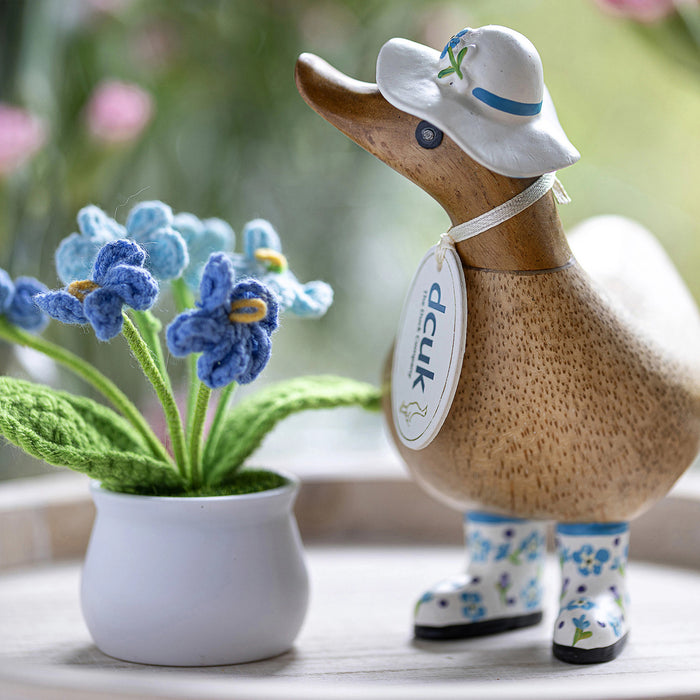 Handmade DCUK wood duck wearing a forget-me-not flower hat and matching boots, part of the DCUK wooden duck gift collection.