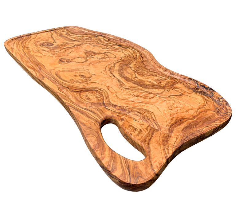 Oblong olive wood cutting board with juice groove, fluid lines, and grip handle. Dimensions: 23-1/2 x 11 x 1/2 inches. Can be used as a presentation or charcuterie board. Rustic elegance, rich vibrant color, and organic look and feel.