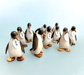Handcrafted wooden Emperor Penguin figurines with name tags displayed on light background