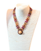 Beaded Diana Necklace in Exotic Woods with intricate details and unique hat pendant displayed on a mannequin