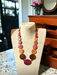 Long Emily Wood Disc Necklace in Central American Woods displayed on a mannequin in a cozy room ambiance