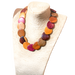 Wood necklace with assorted colorful wooden beads displayed on a woven stand