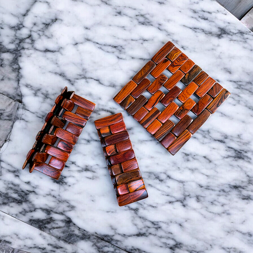 Cocobola folding wooden trivet on kitchen countertop.