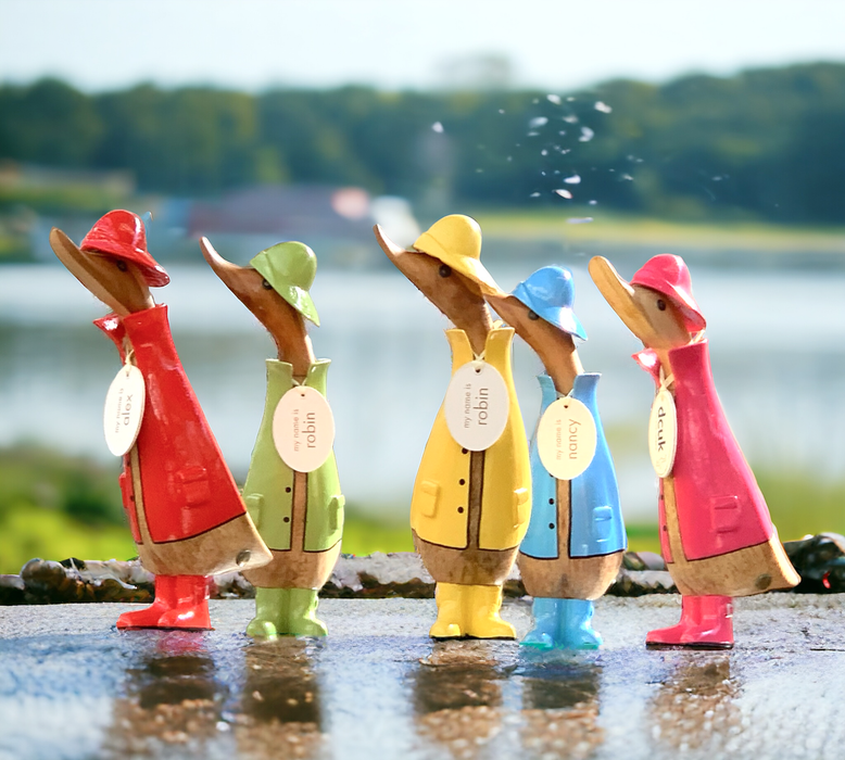 A group of bamboo root ducklings sporting bright colored  raincoats or rain gear