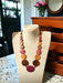 Long Emily Wood Disc Necklace in Central American Woods displayed on a mannequin in a cozy room ambiance