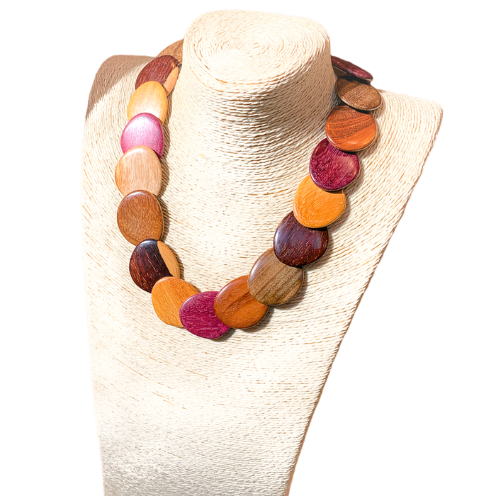 Wood necklace with assorted colorful wooden beads displayed on a woven stand