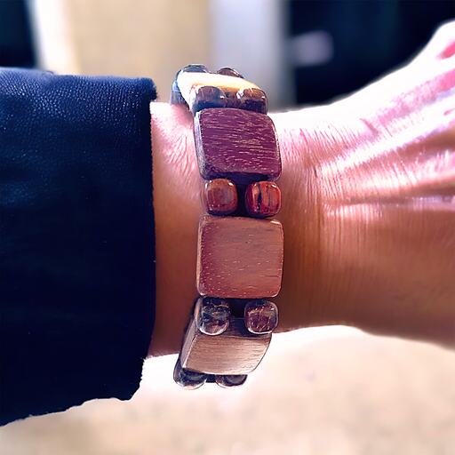 Wood stretch bracelet with square tiles and tiny beads on wrist, featuring natural colors and exotic woods.